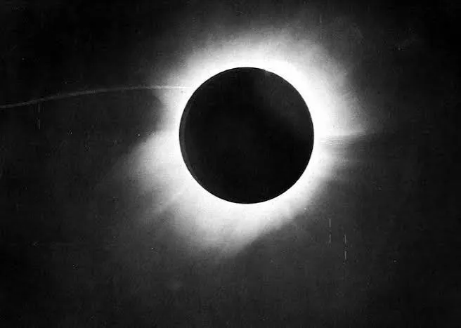 Fotografia in bianco e nero di un'eclissi totale di Sole: il disco scuro della Luna al centro, circondato dalla corona luminosa, su un cielo scuro.