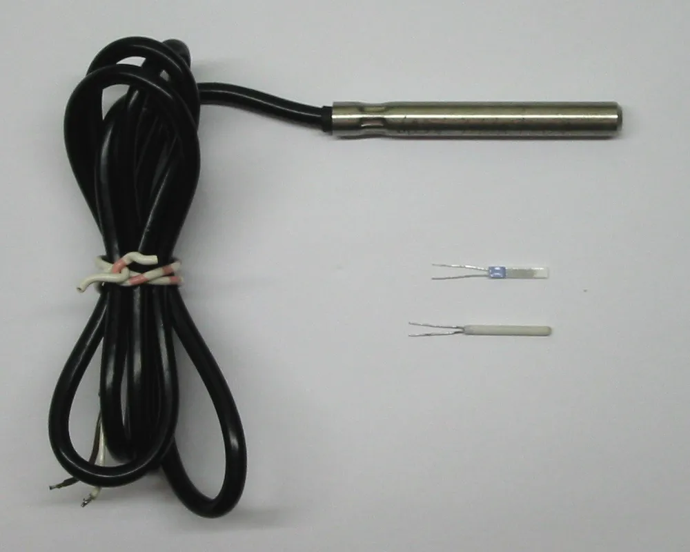 Tre sensori di temperatura: una sonda con un tubetto metallico all'estremità di un cavo nero arrotolato e, accanto, due piccoli elementi nudi con due fili sottili, uno piatto e uno cilindrico.
